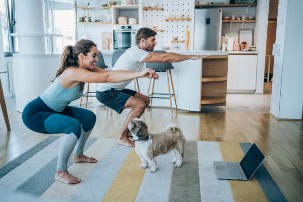 couple exercising in living room with their dog