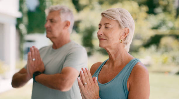 Namaste, peace and yoga pose with mature people for calm, relax and spiritual practice. Female person, eyes closed and zen in home for balance, meditation and wellness in mental health with awareness