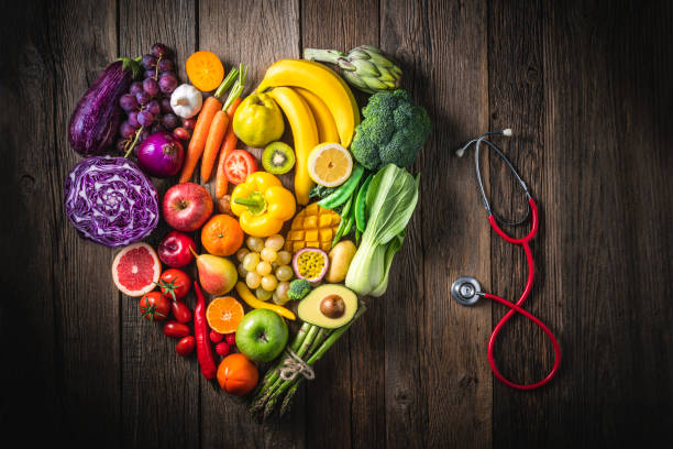 Vegetables and fruit with heart shape as concept of cardiovascular health on wooden rustic table