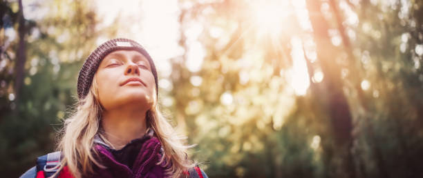 Young woman hiking and going camping in nature. Person with backpack walking in the forest